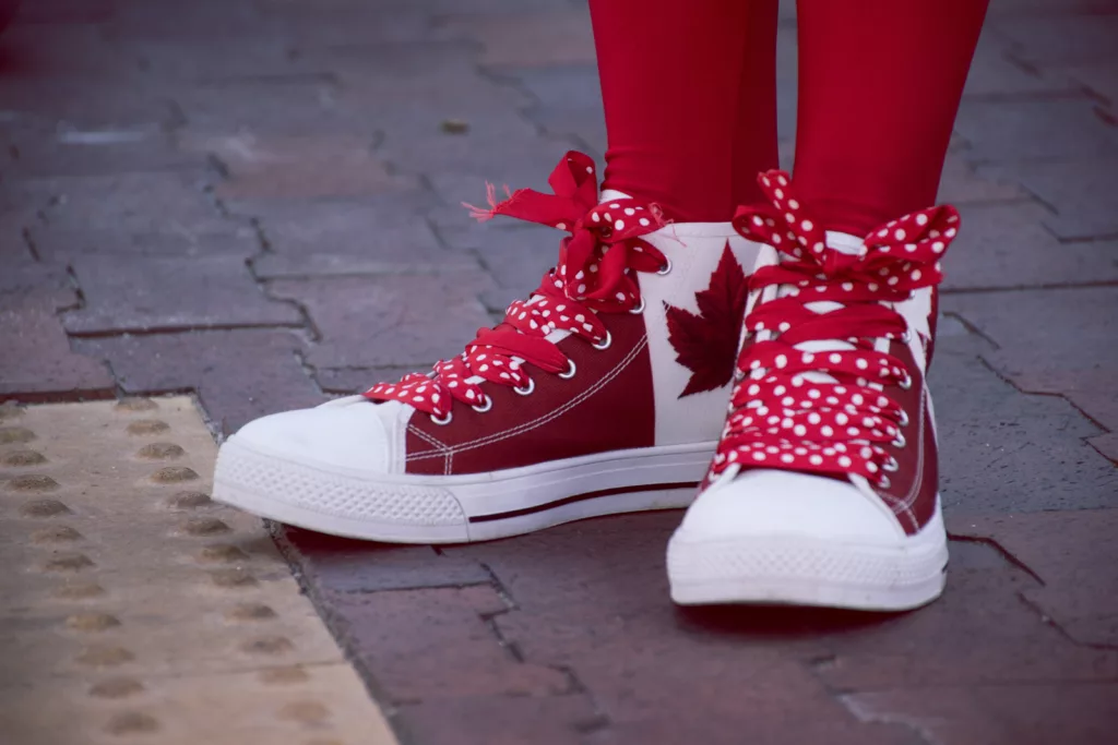 Nærbilde av person i røde og hvite sko med bladmønster