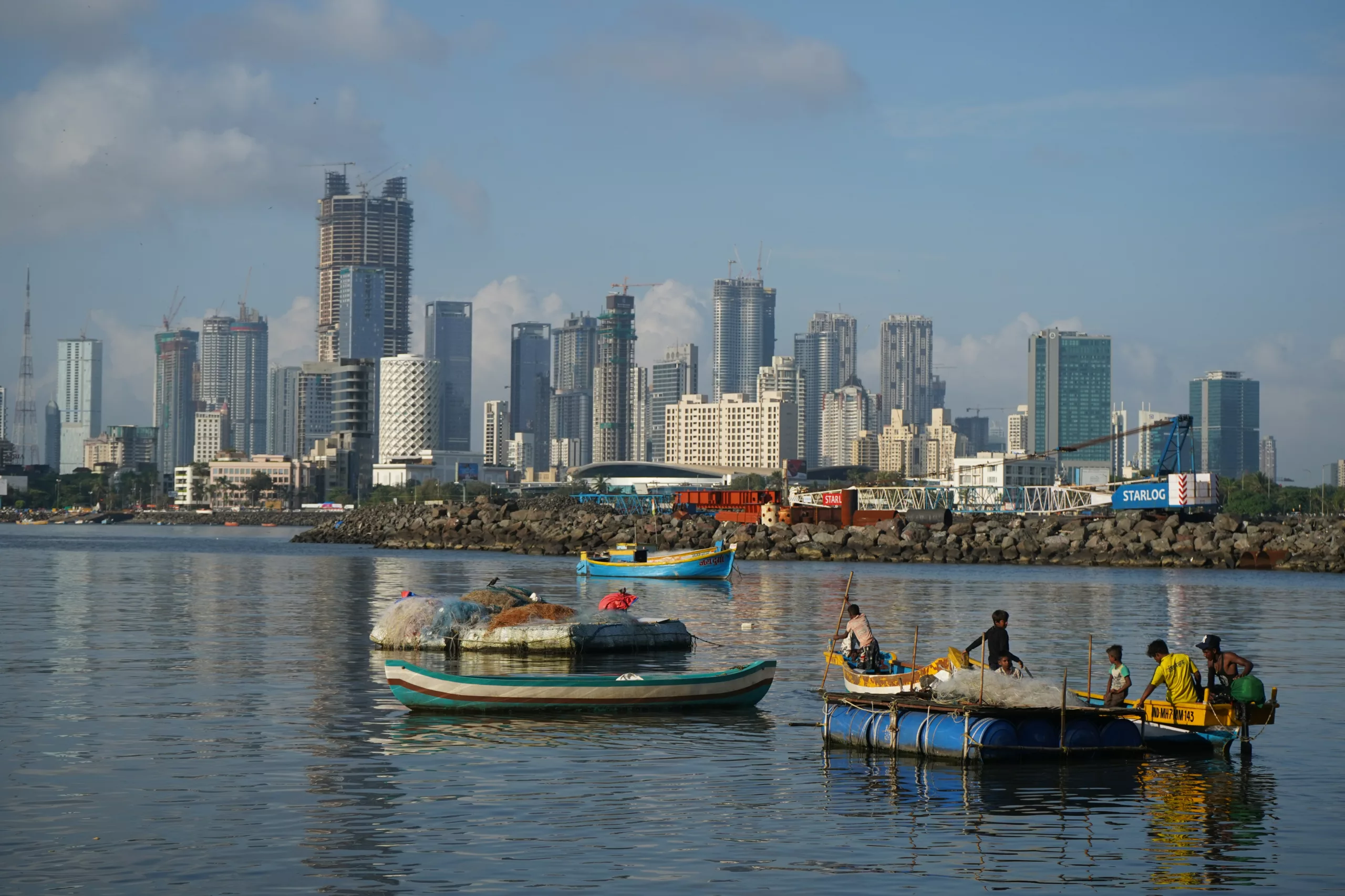 Mumbai by med høyblokker, fiskere på vann i forgrunnen