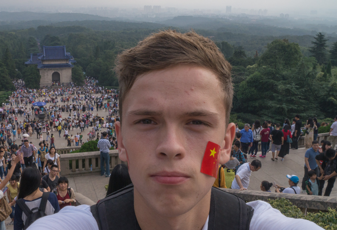 Ung mann med kinesisk flagg på kinnet