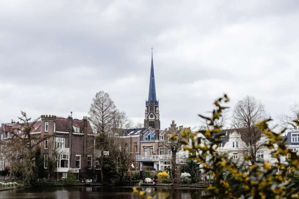 Skyline i Nederland med gammel kirke og gule blomster i forgrunnen