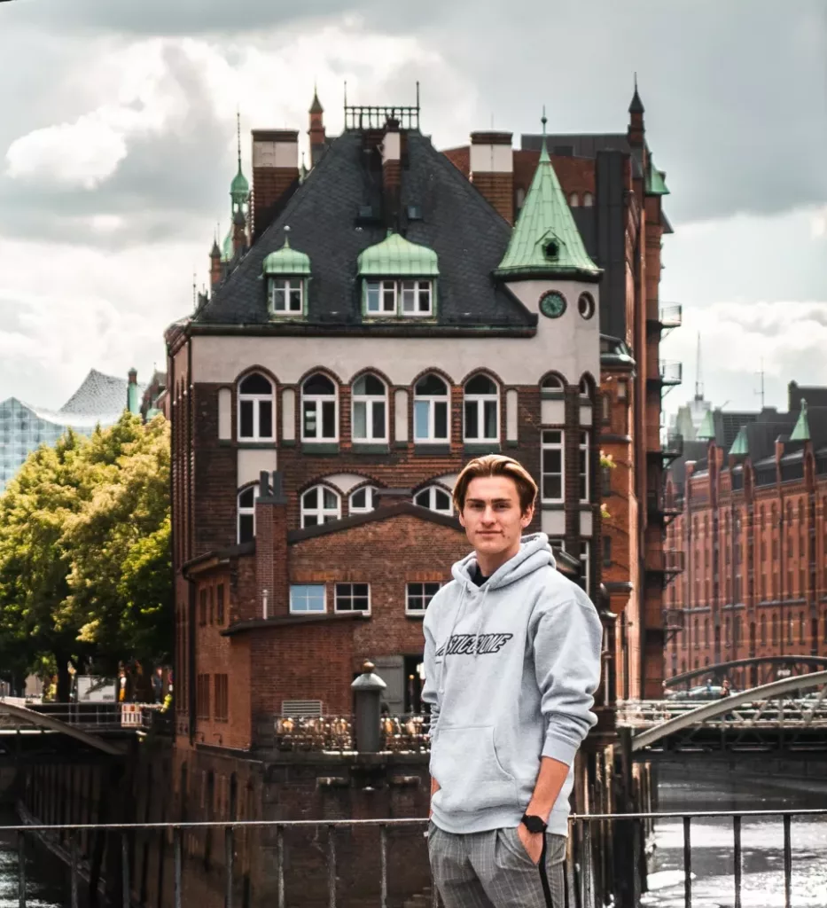 Ung, norsk mann står foran en tysk bygning