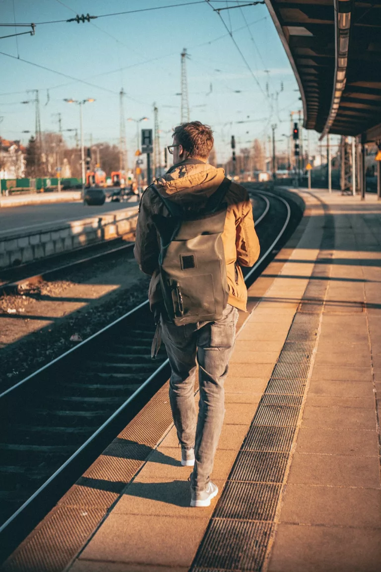 Ung mann med ryggen til kamera går langs en togperrong