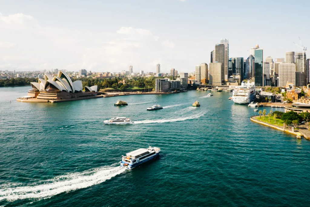 Havneomårde med båter i vannet og Sydney opera house