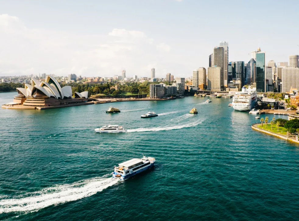 Havneomårde med båter i vannet og Sydney opera house