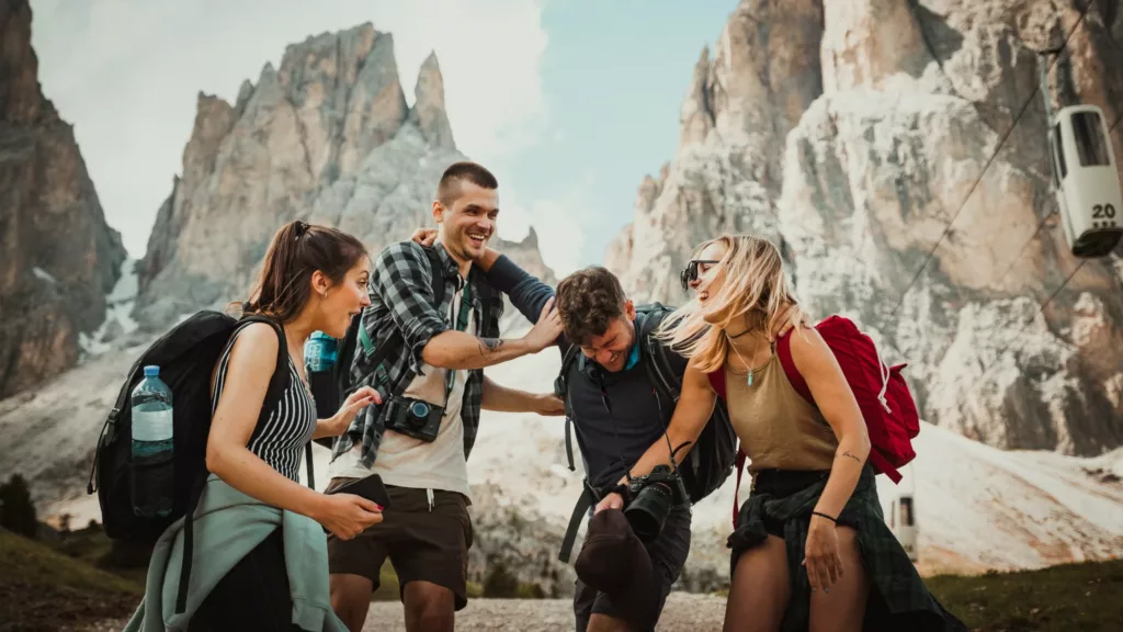 Gruppe med unge, glade mennesker foran fjell