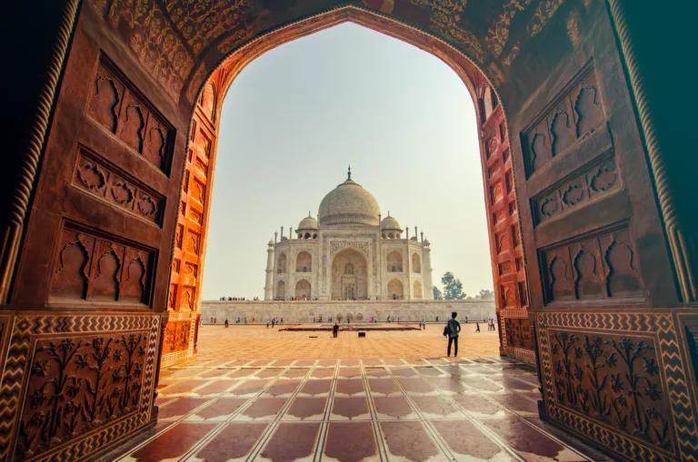 Inngangsportal i India med stort tempel innenfor