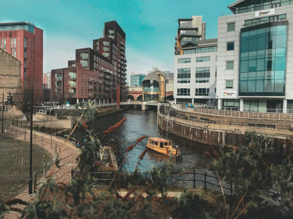 Bybilde med moderne blokker og en gul båt på en kanal
