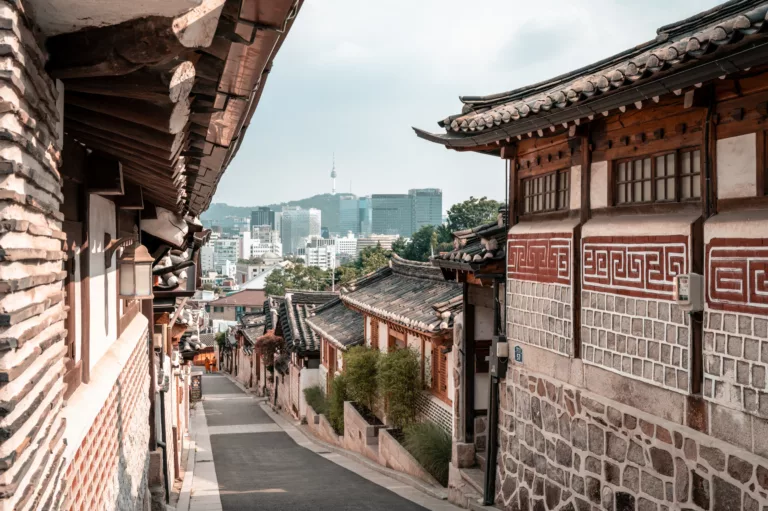 Koreansk nabolagsgate som går mot bysentrum med bylandskap i bakgrunnen
