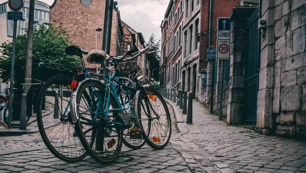To sykler står parkert på en brosteinsgate i Liege i Belgia