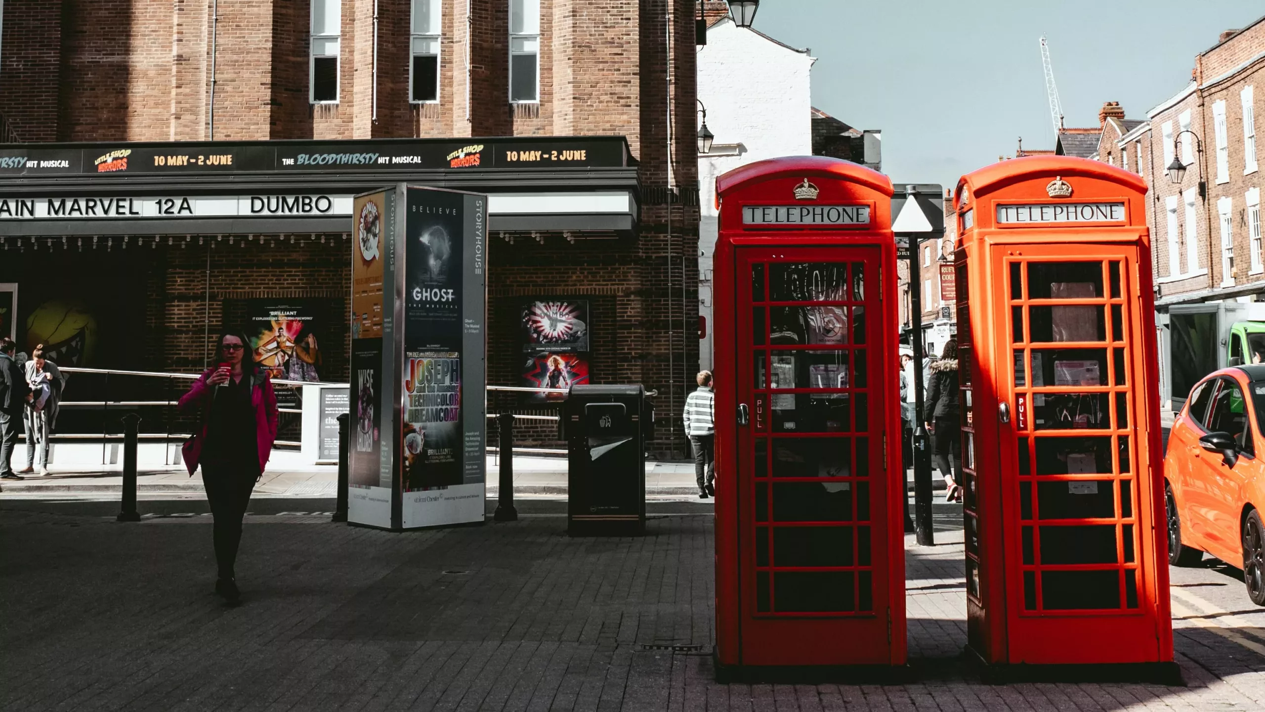 To røde telefonkiosker står på en gate i Storbritannia