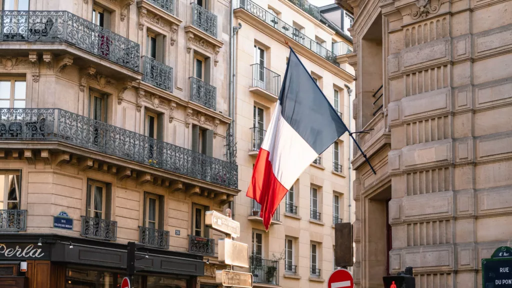 Gate i Paris med et stort fransk flagg hengende foran en dør