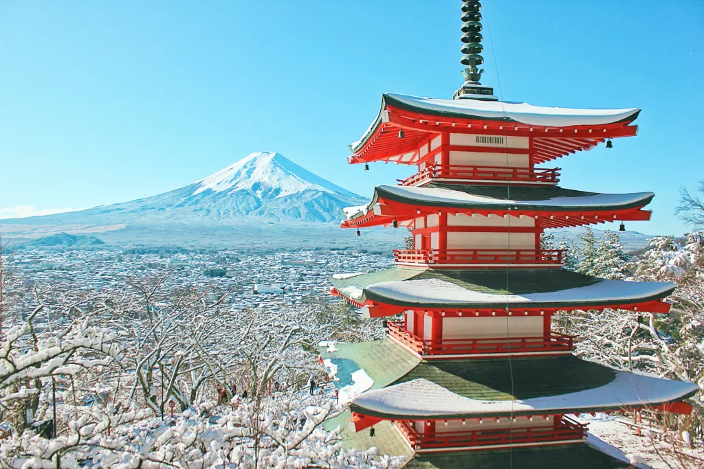 Japansk tårn med fjell i bakgrunnen