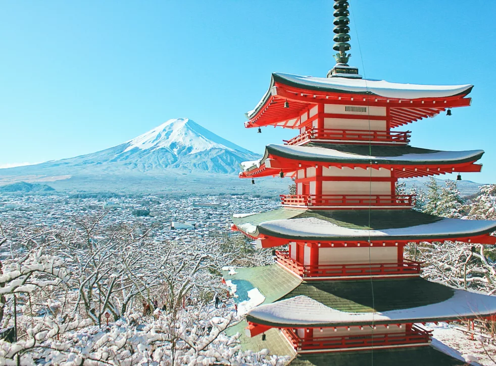 Japansk tårn med fjell i bakgrunnen