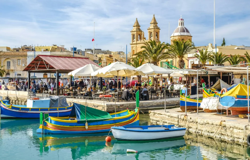 En havn med fargerike båter og turkist vann