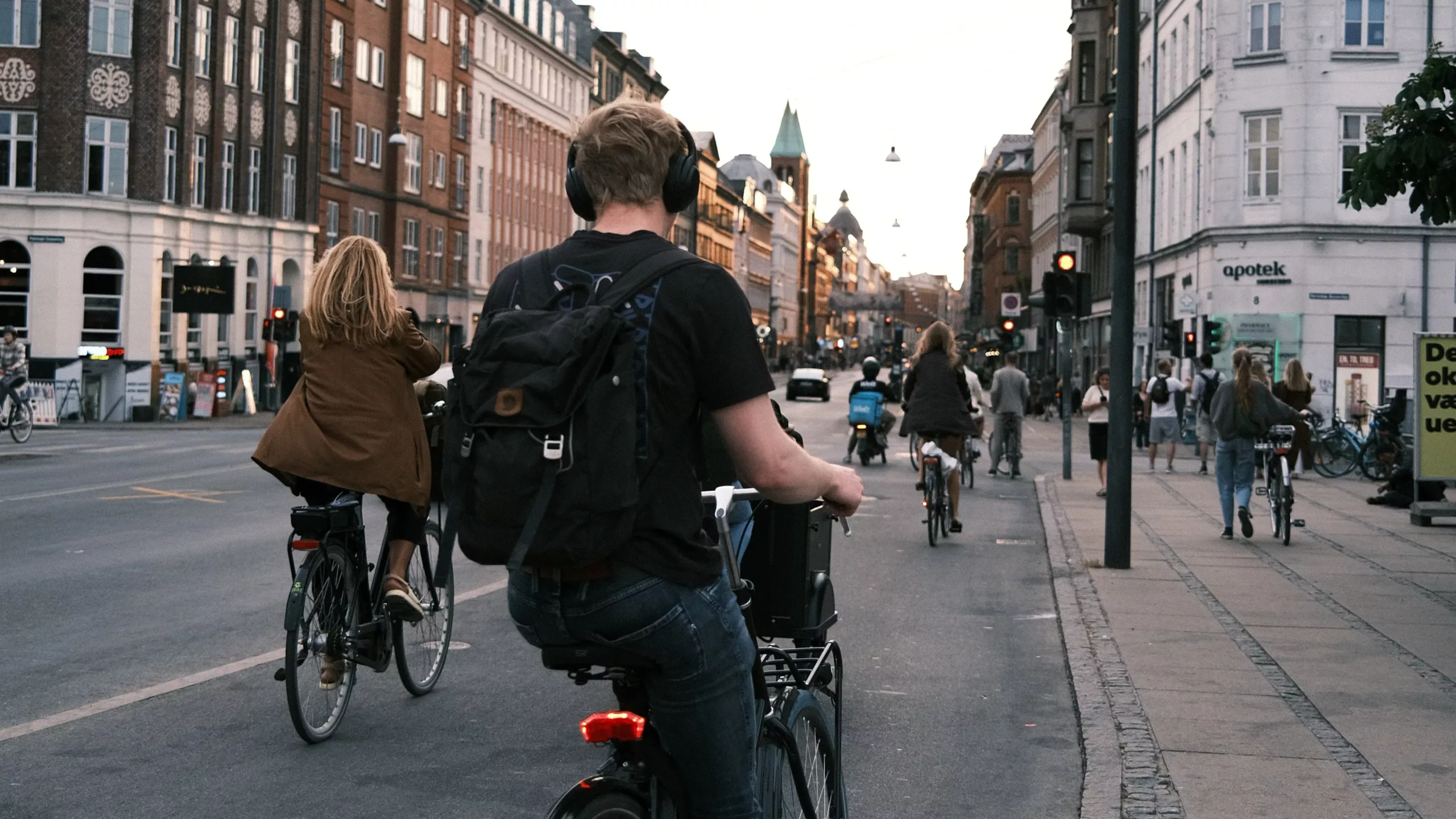 En ung mann i T-skjorte sykler i en gate i Dublin, Irland