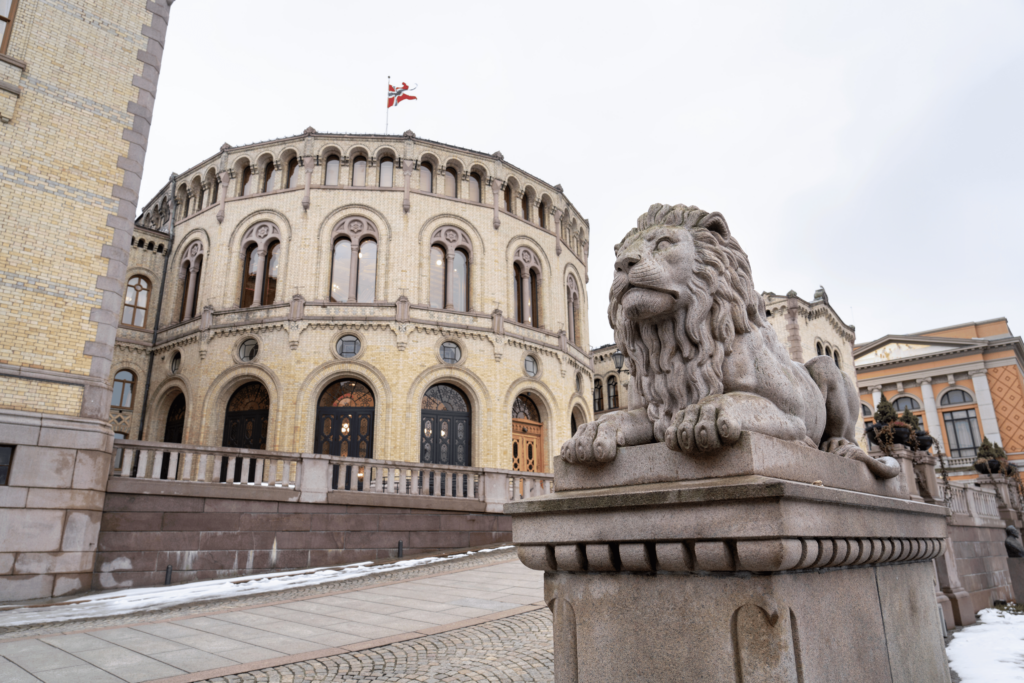 Lys murbygning med en løve i stein utenfor