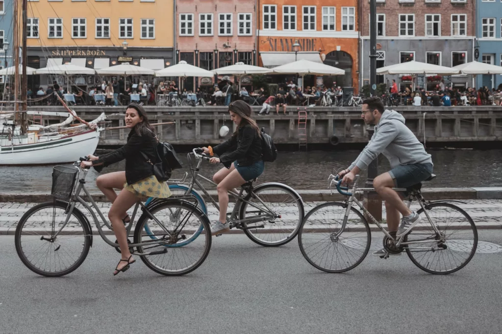 Tre personer sykler langs en brygge