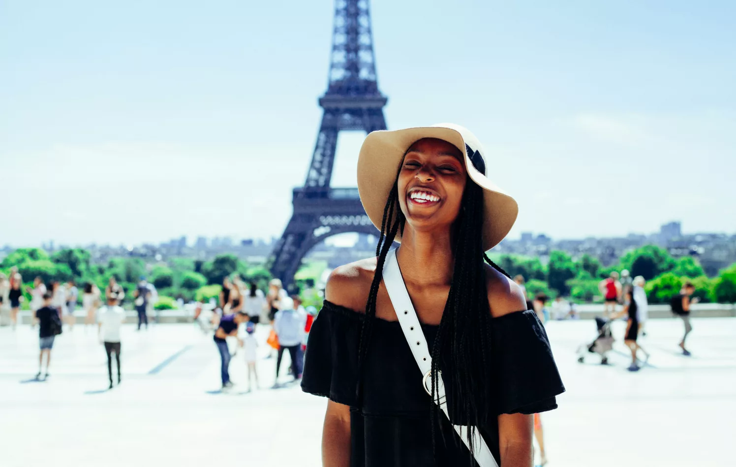 Ung kvinne med hatt foran Eiffeltårnet