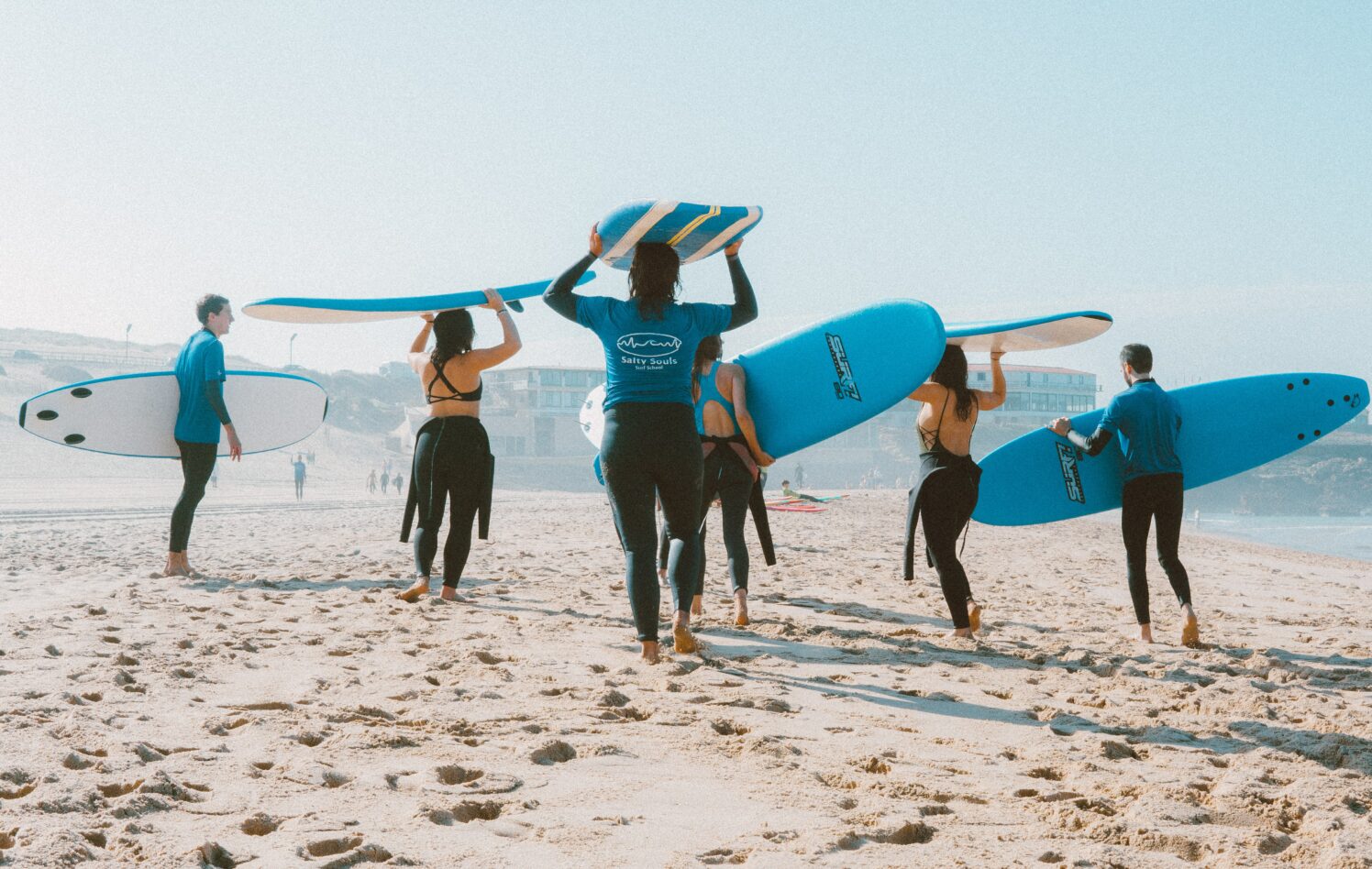 Personer med surfebrett på en strand